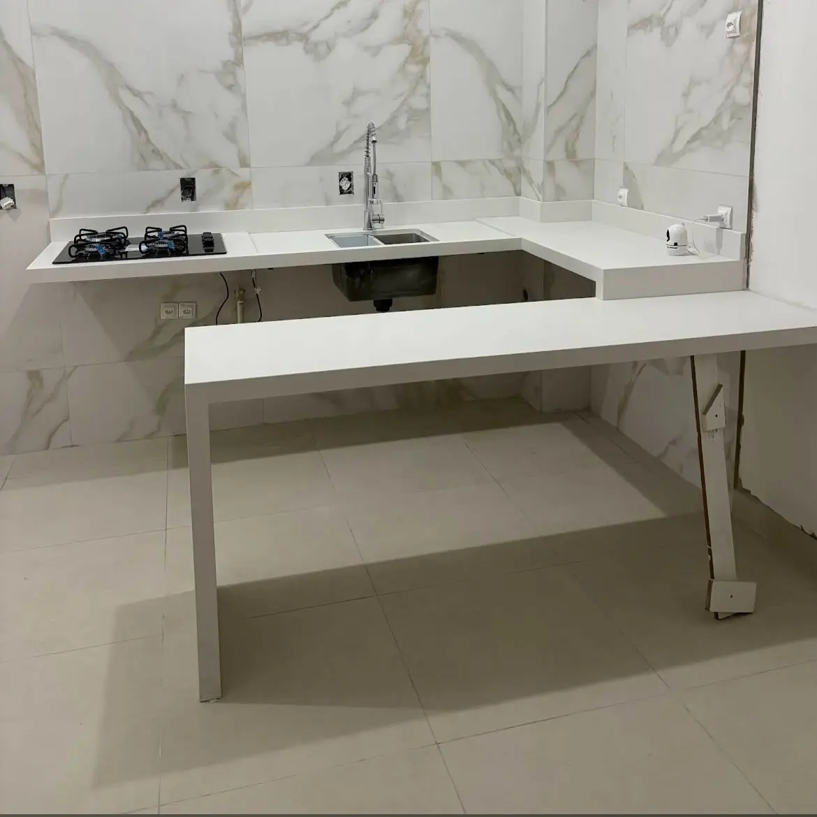 Bancada e mesa em pedra clara em cozinha integrada